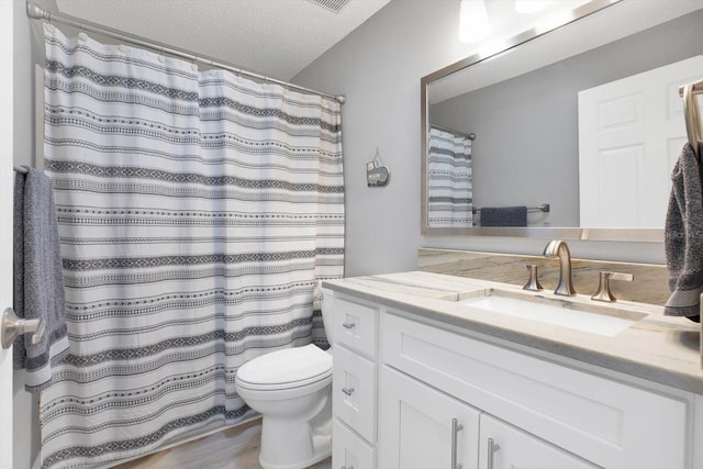 bathroom with a shower with curtain, a textured ceiling, wood-type flooring, vanity, and toilet