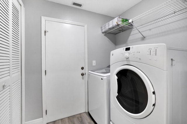 washroom featuring light wood-type flooring and washing machine and dryer