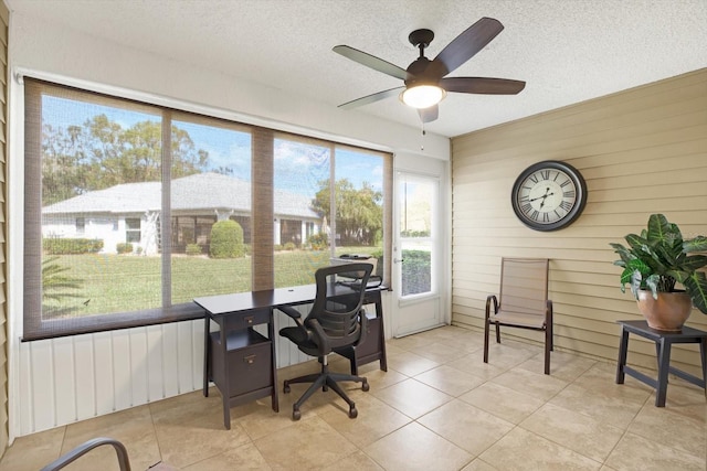 tiled office featuring wood walls, ceiling fan, and a textured ceiling