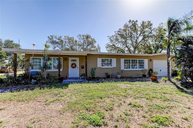 ranch-style house featuring a garage and a front yard