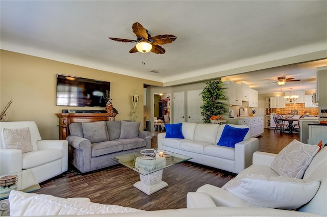 living room featuring ceiling fan, sink, and dark hardwood / wood-style floors