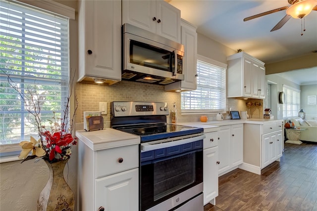 kitchen with white cabinetry, stainless steel appliances, and dark wood-type flooring