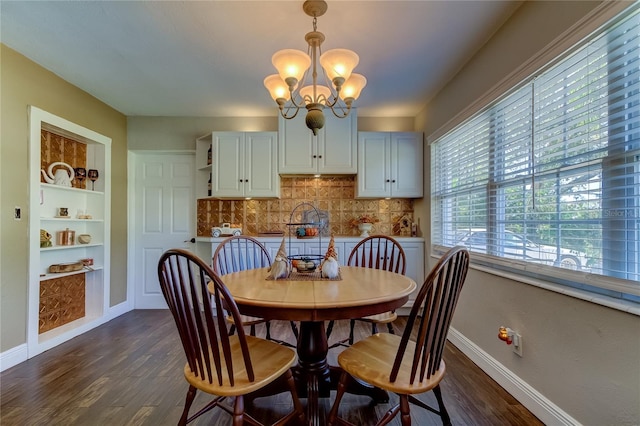 dining space with dark hardwood / wood-style flooring, built in features, and an inviting chandelier