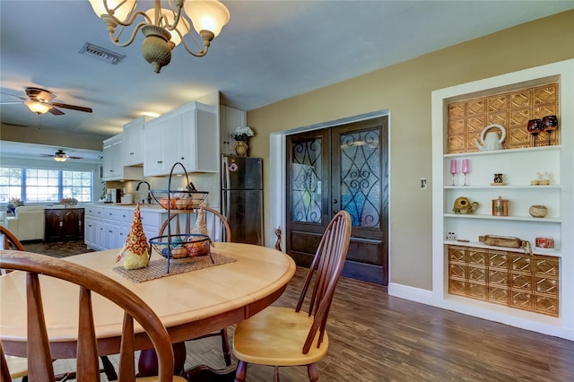 dining room featuring ceiling fan with notable chandelier, dark hardwood / wood-style floors, and sink