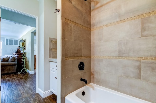 bathroom featuring tiled shower / bath combo and hardwood / wood-style floors