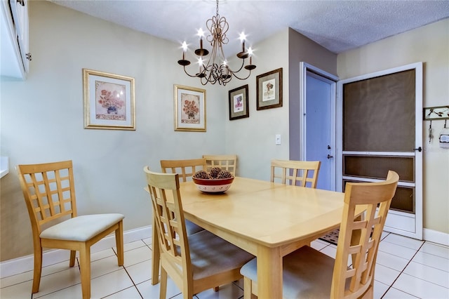 tiled dining room featuring a textured ceiling and a chandelier