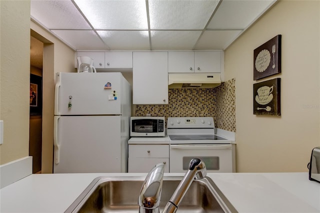 kitchen with decorative backsplash, white cabinetry, a paneled ceiling, and white appliances