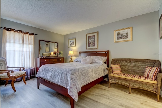 bedroom with light hardwood / wood-style flooring and a textured ceiling