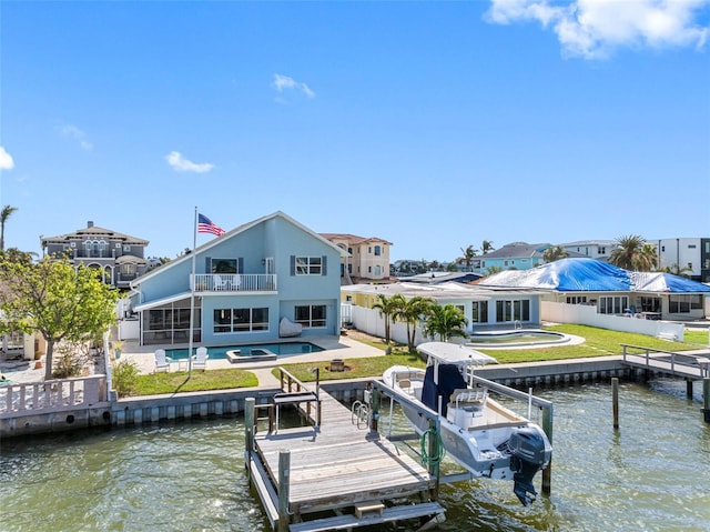 dock area featuring a balcony, a yard, and a water view