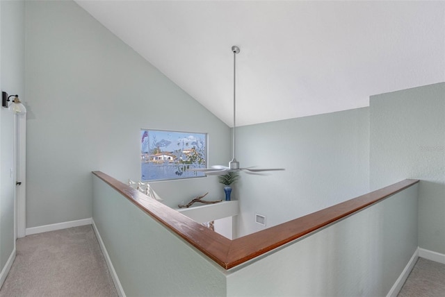 hallway with light colored carpet and vaulted ceiling