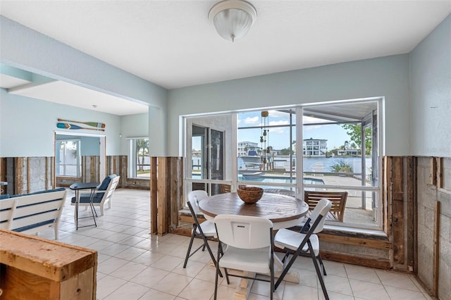 dining room with a water view and light tile patterned floors