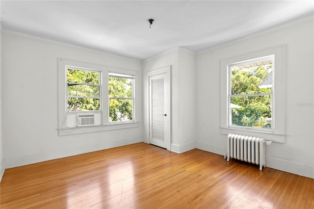 interior space with radiator, ornamental molding, and light wood-type flooring