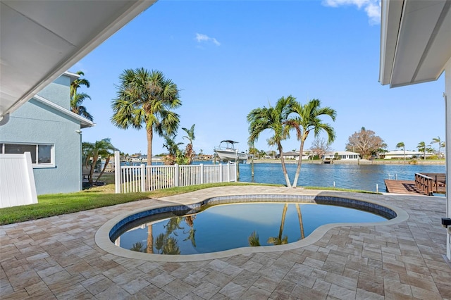 view of swimming pool featuring a lawn, a water view, and a patio area