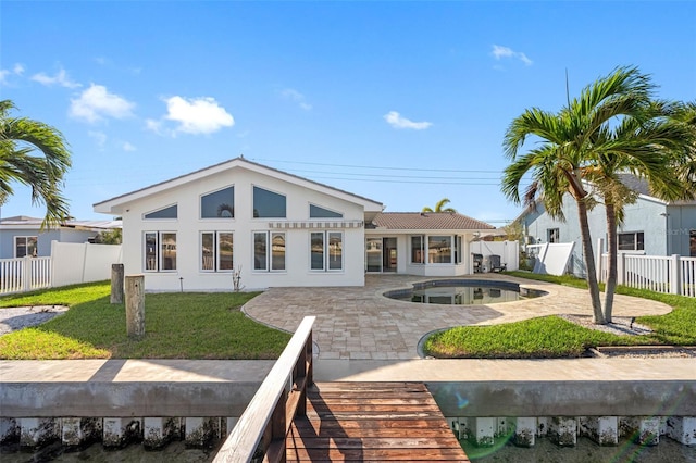 rear view of house featuring a patio area, a yard, and a fenced in pool