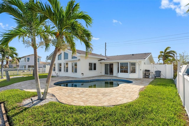 back of property featuring a fenced in pool, a yard, and a patio area