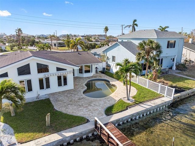 rear view of property featuring a lawn and a patio