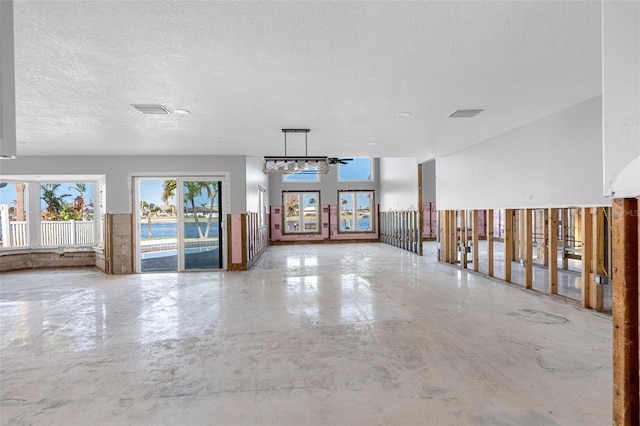 empty room with concrete flooring, a textured ceiling, and ceiling fan