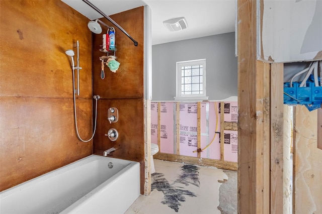 bathroom featuring concrete flooring, toilet, and bathtub / shower combination