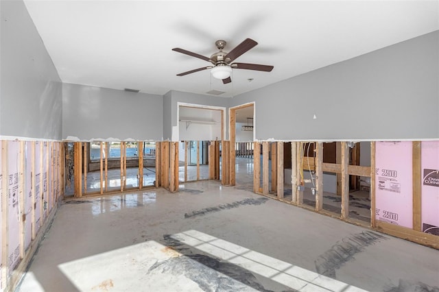 unfurnished room with ceiling fan and concrete floors