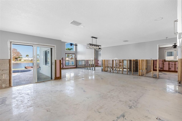 spare room with concrete flooring, a textured ceiling, and ceiling fan