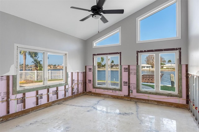 interior space with concrete flooring, ceiling fan, a healthy amount of sunlight, and a water view