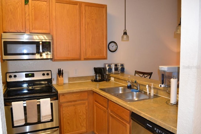 kitchen featuring decorative light fixtures, appliances with stainless steel finishes, and sink