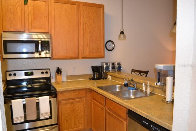 511 Rum Run Unit 33-511, Davenport, FL 33897 - kitchen with stainless steel appliances, a sink, light countertops, and hanging light fixtures