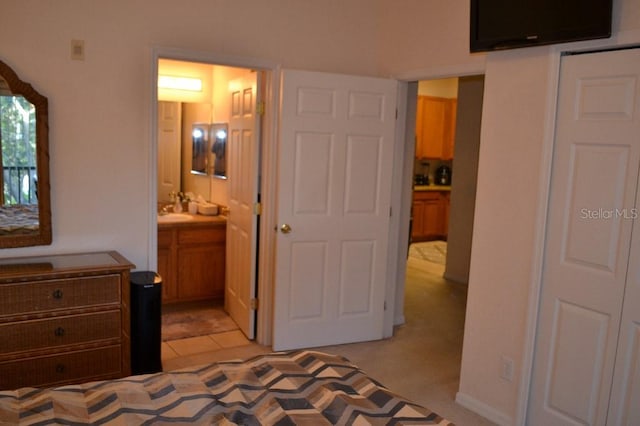 carpeted bedroom featuring connected bathroom and sink