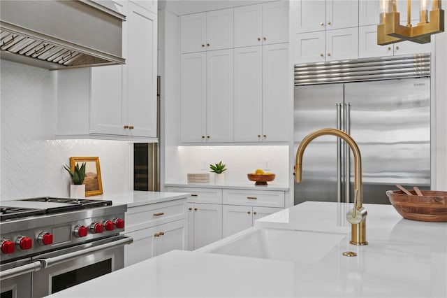 kitchen with premium range hood, white cabinetry, high quality appliances, and tasteful backsplash