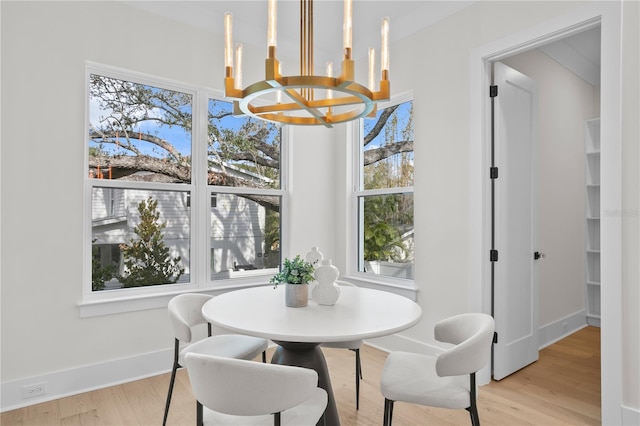 dining space with an inviting chandelier and light hardwood / wood-style floors