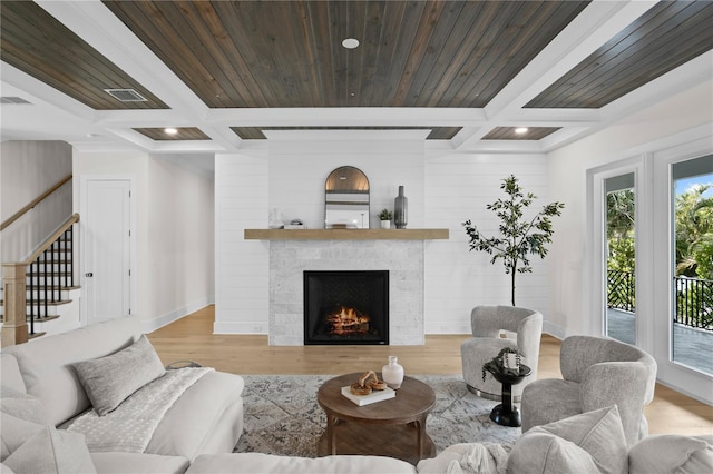 living room featuring beamed ceiling, coffered ceiling, wood ceiling, and light hardwood / wood-style flooring