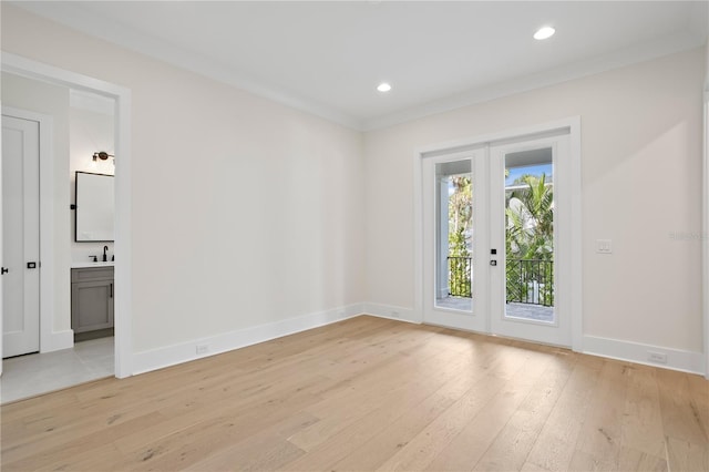 unfurnished room with ornamental molding, sink, light hardwood / wood-style floors, and french doors