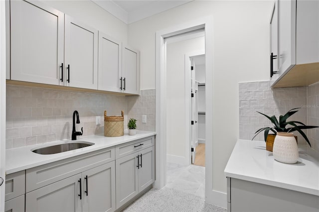 kitchen with tasteful backsplash, sink, and gray cabinetry