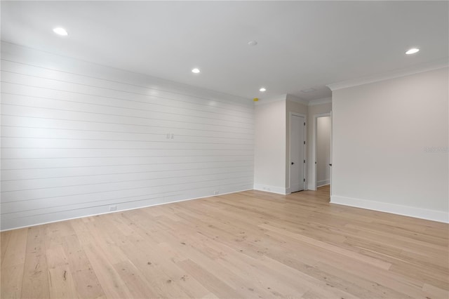 unfurnished room with crown molding and light wood-type flooring