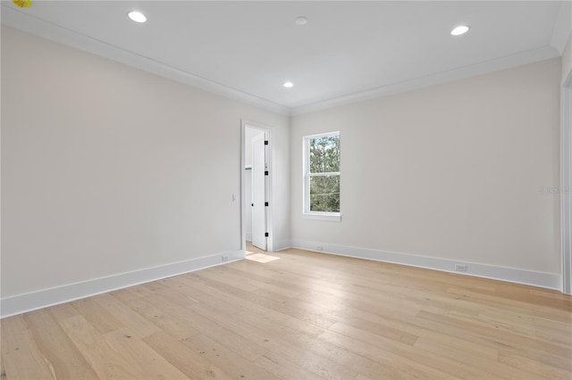 empty room with ornamental molding and light wood-type flooring