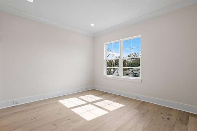 spare room featuring crown molding and light wood-type flooring