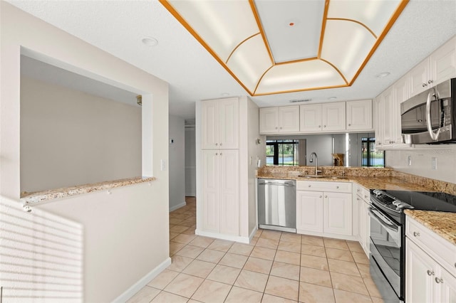 kitchen with appliances with stainless steel finishes, white cabinetry, sink, and light tile patterned floors