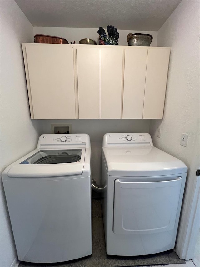 laundry area with washing machine and dryer and cabinets