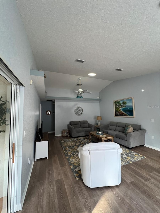 living room with ceiling fan, a textured ceiling, lofted ceiling, and dark hardwood / wood-style flooring