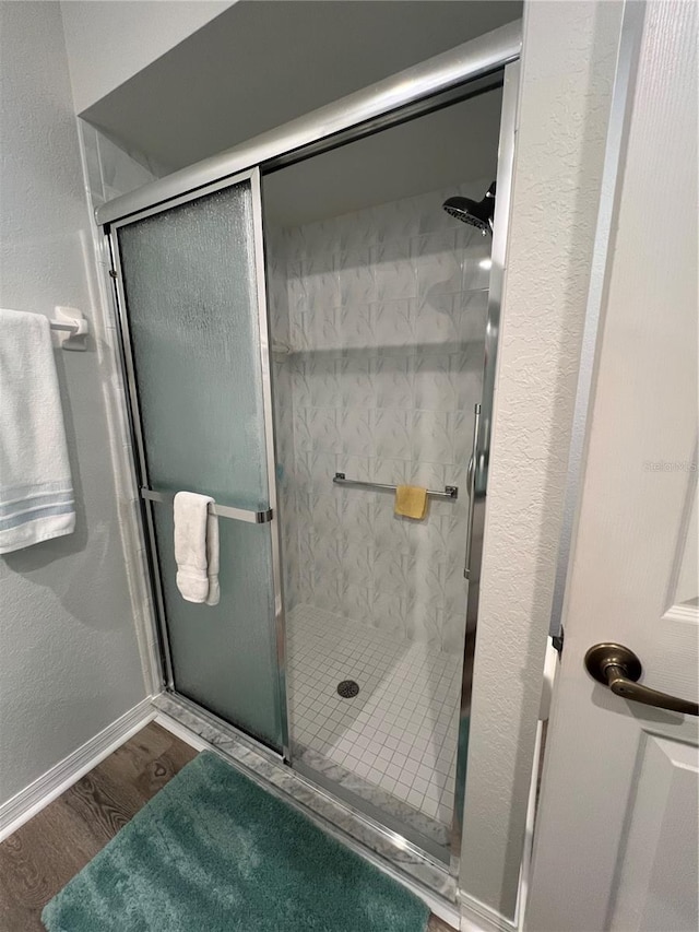 bathroom featuring a shower with door and hardwood / wood-style floors