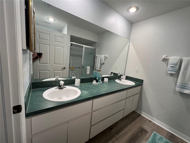 bathroom with vanity, hardwood / wood-style floors, a textured ceiling, and an enclosed shower