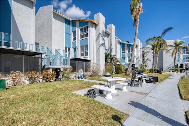 view of property's community featuring a patio and a yard