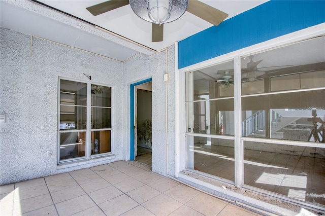 unfurnished sunroom featuring ceiling fan