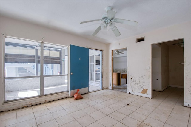 spare room with ceiling fan and light tile patterned floors