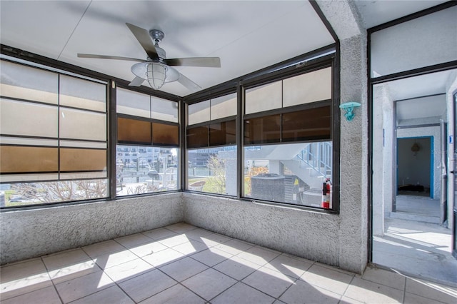 unfurnished sunroom with ceiling fan