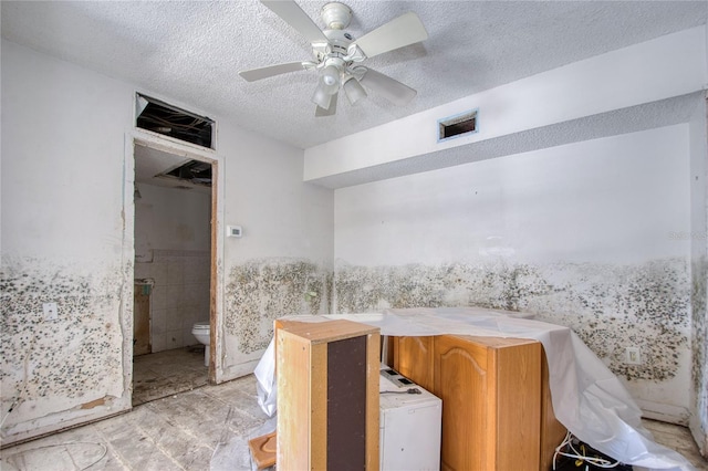 bathroom featuring toilet, a textured ceiling, and ceiling fan