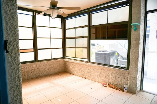 unfurnished sunroom with a ceiling fan