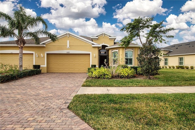 single story home with a garage and a front lawn