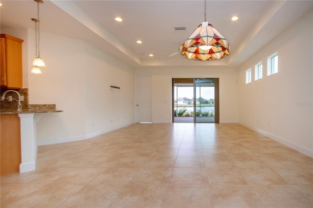 spare room featuring sink and a tray ceiling