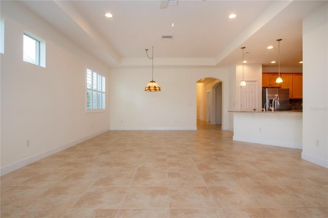 unfurnished living room featuring a raised ceiling